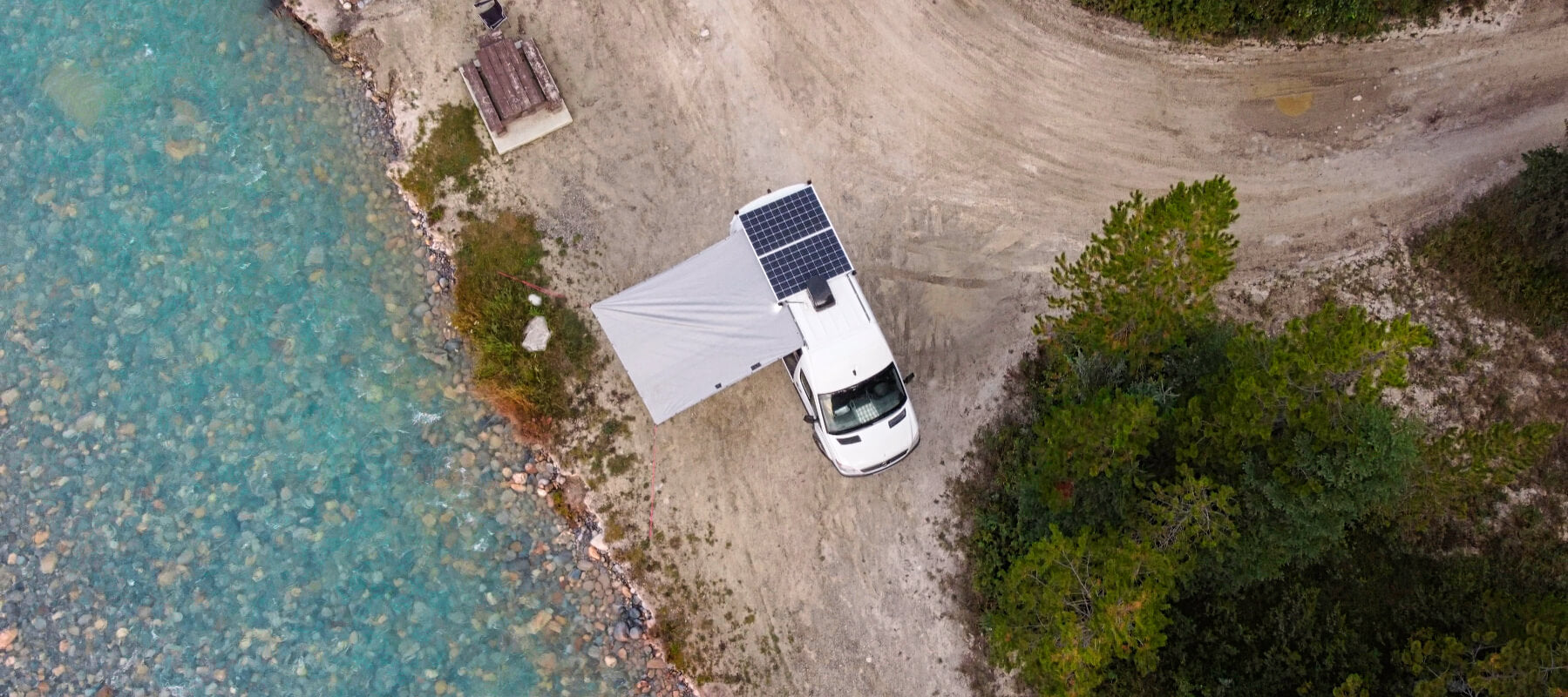 Lonavity Vanlife Columbia-Shuswap, blue water and view of the van from the top with solar panels and DIY awning