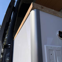 Aluminum corner profile installed on van conversion cabinet for support.