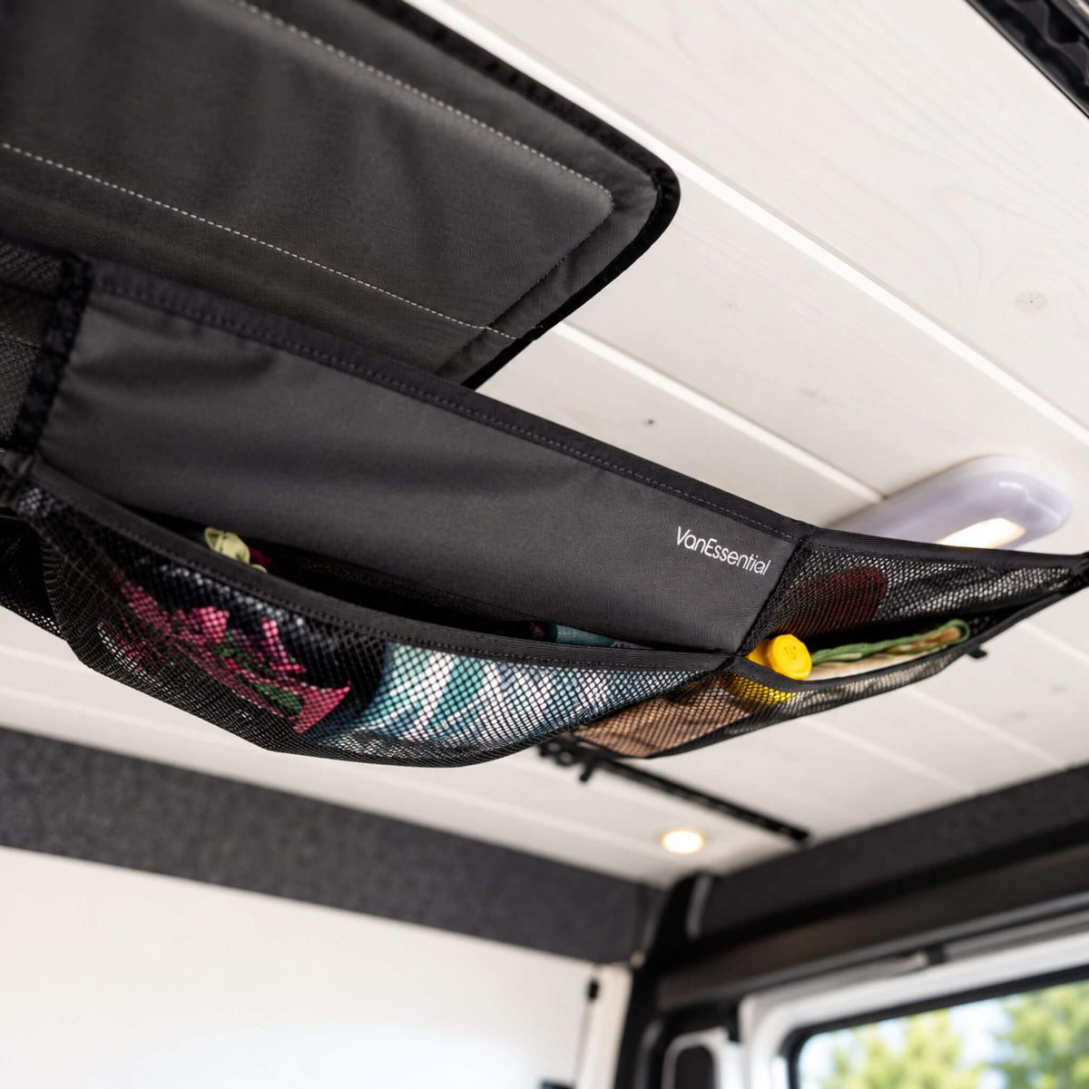 Medium 34 x 13 inch cargo net with mesh and fabric compartments for organized campervan and RV storage.