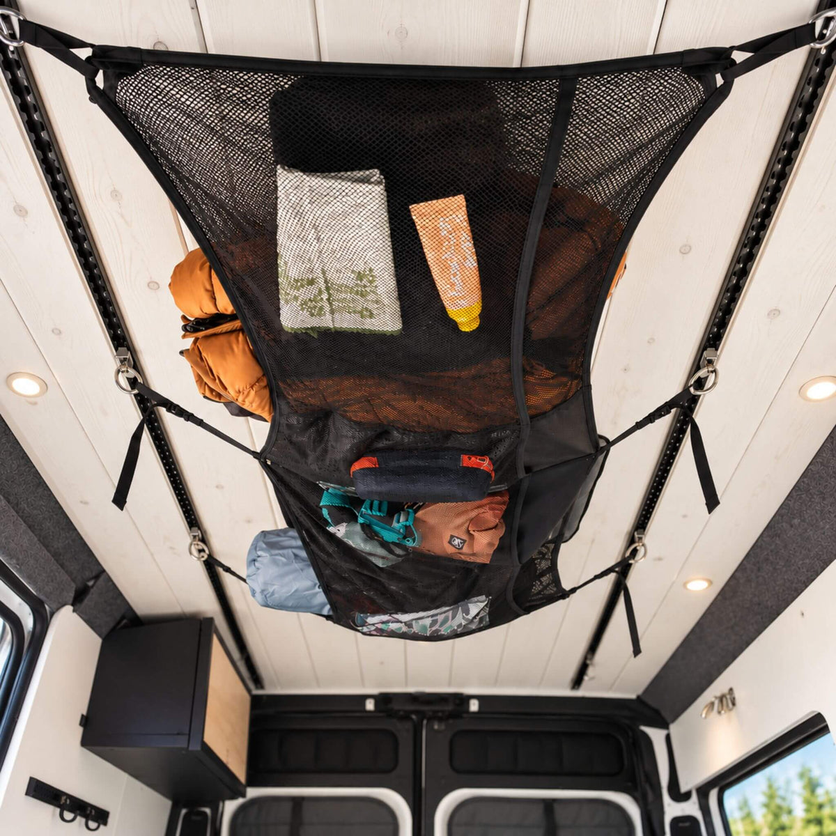 Small 23 x 11 inch cargo net with mesh and fabric pockets for compact campervan storage and organization.