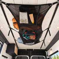 Small 23 x 11 inch cargo net with mesh and fabric pockets for compact campervan storage and organization.