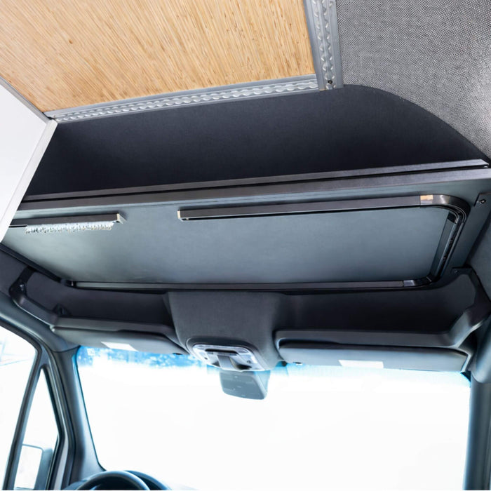Sprinter cockpit view showing an aluminum headliner shelf integrated with factory visors and grab handles.