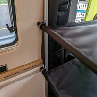 Twin bunk bed system folded and stored neatly along the main bed. / Système de lits superposés replié et rangé soigneusement le long du lit principal.