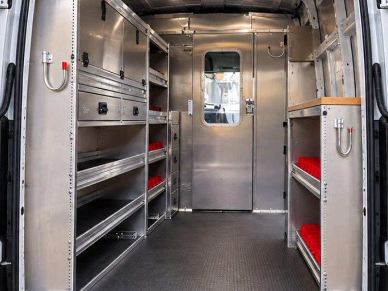 Intérieur de van de travail Ford Transit avec étagères en aluminium, tiroirs et porte de cloison pour entrepreneurs.