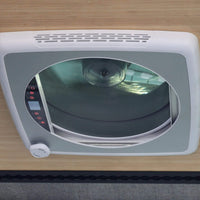 White roof fan installed in a van conversion with integrated lighting / Ventilateur de toit blanc installé dans une conversion de van avec éclairage intégré.