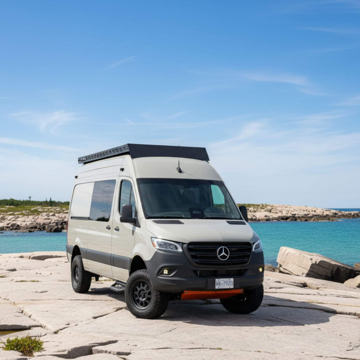 Carbon fiber rooftop tent system on a Sprinter van designed for sleeping above the landscape