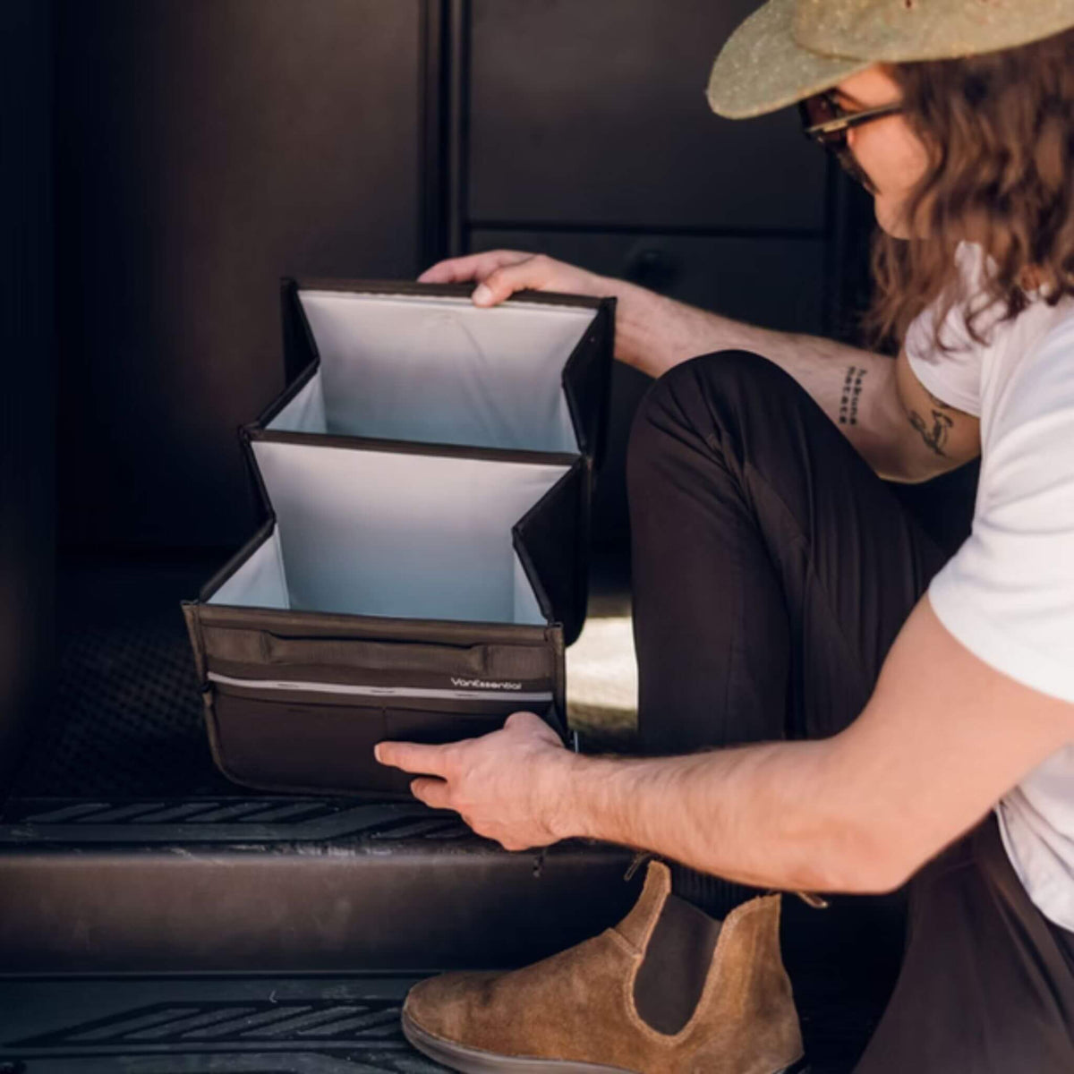 Unfolding the VanEssential 18 L collapsible storage box on a van floor.