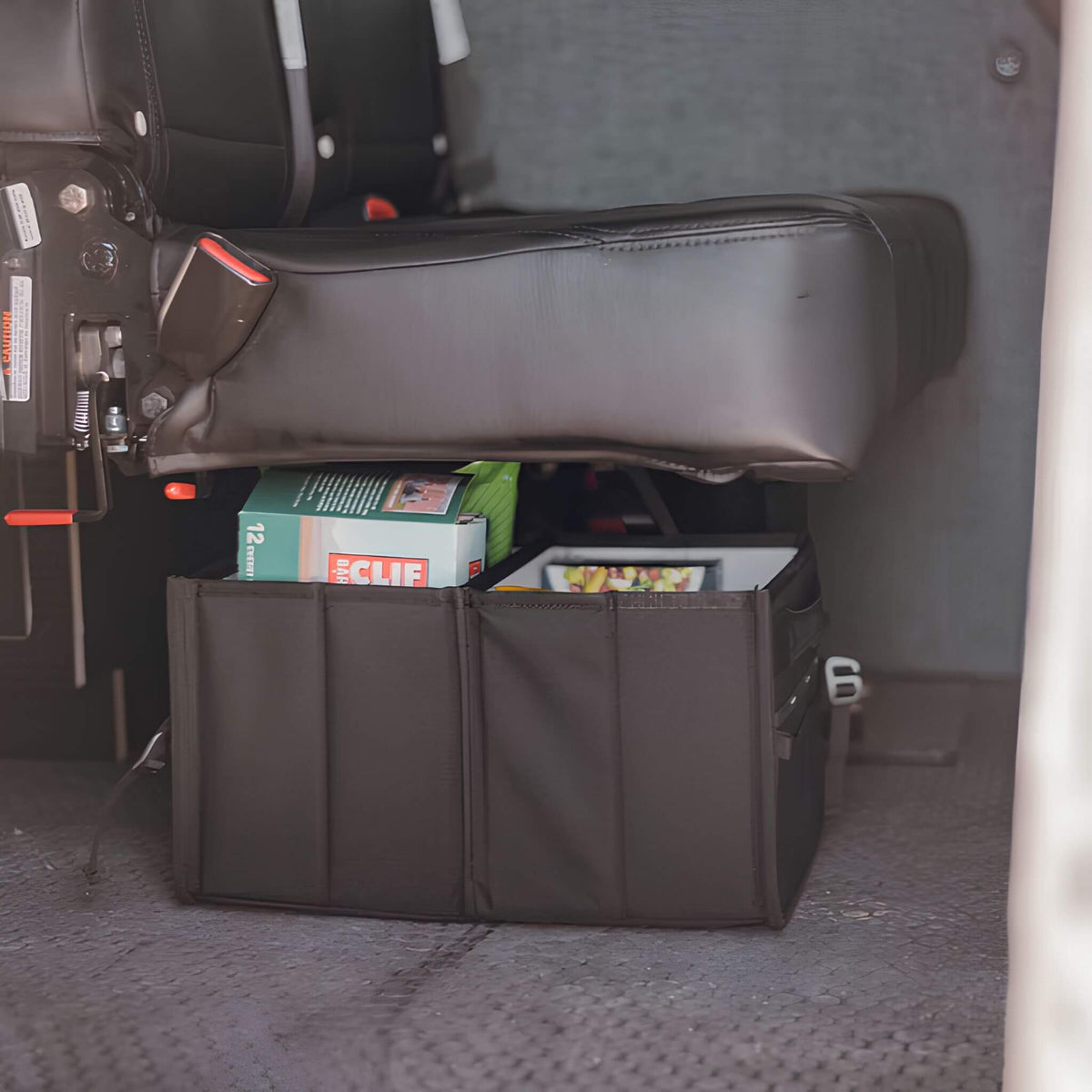 VanEssential 18 L collapsible storage box with divider for floor storage in a van.