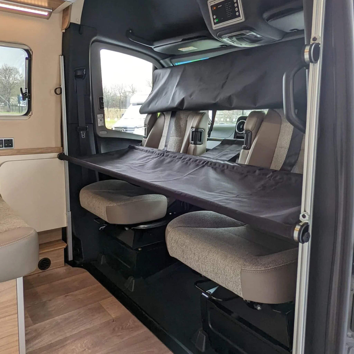 Camper van interior with twin removable bunk beds—ideal for family travel. / Intérieur de van aménagé avec lits superposés amovibles—idéal pour les voyages en famille.